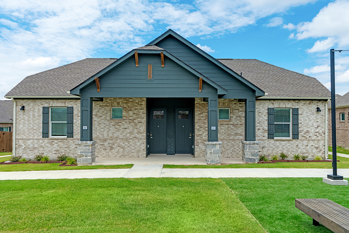 Two single family homes for rent made of brown stone and dark gray siding.