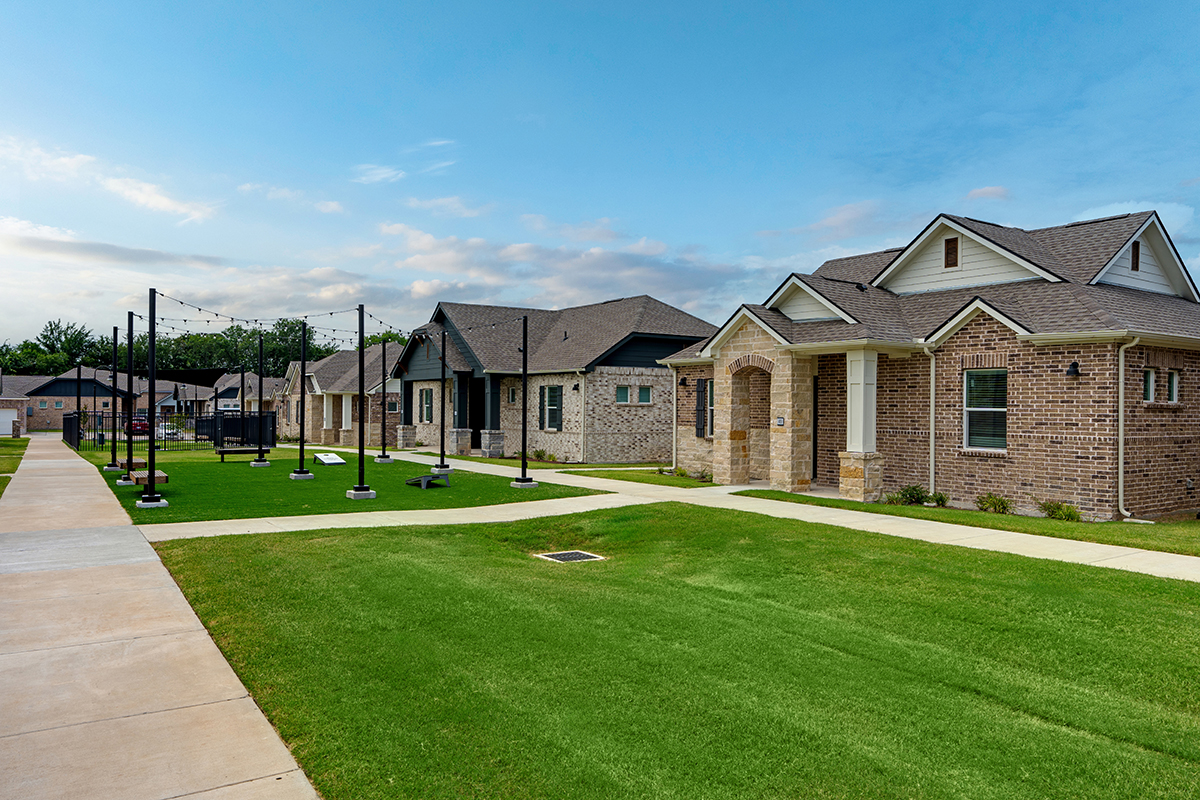 Outdoor, grassy area with lighting, seating, and games in a single family for rent community.