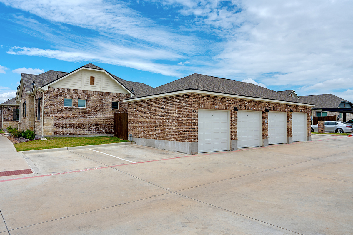 Four-car, detached garage made of red brick in a single family for rent community.