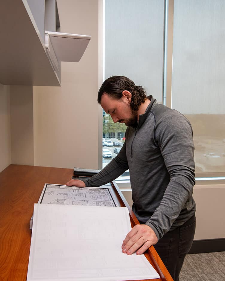 a bbl architect looking at blueprints