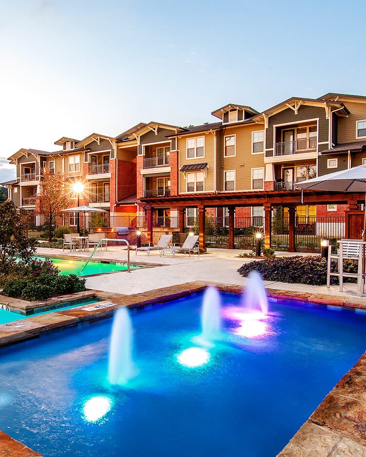 apartment complex with a fountain pool in front
